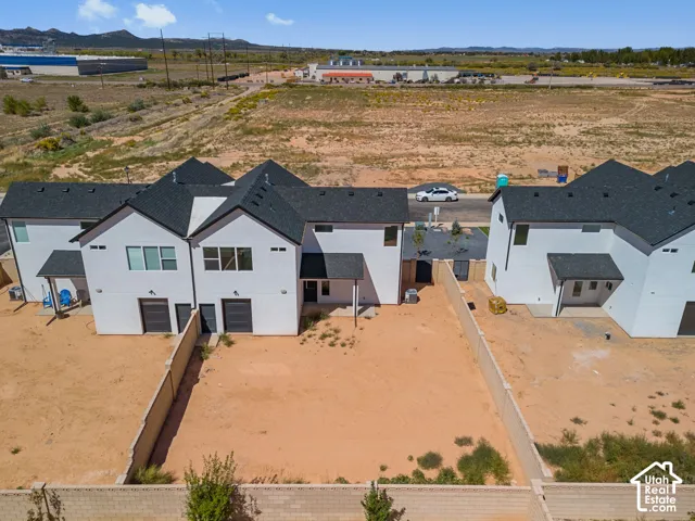 Modern residences featuring white exteriors, dark shingle roofing, and attached garages