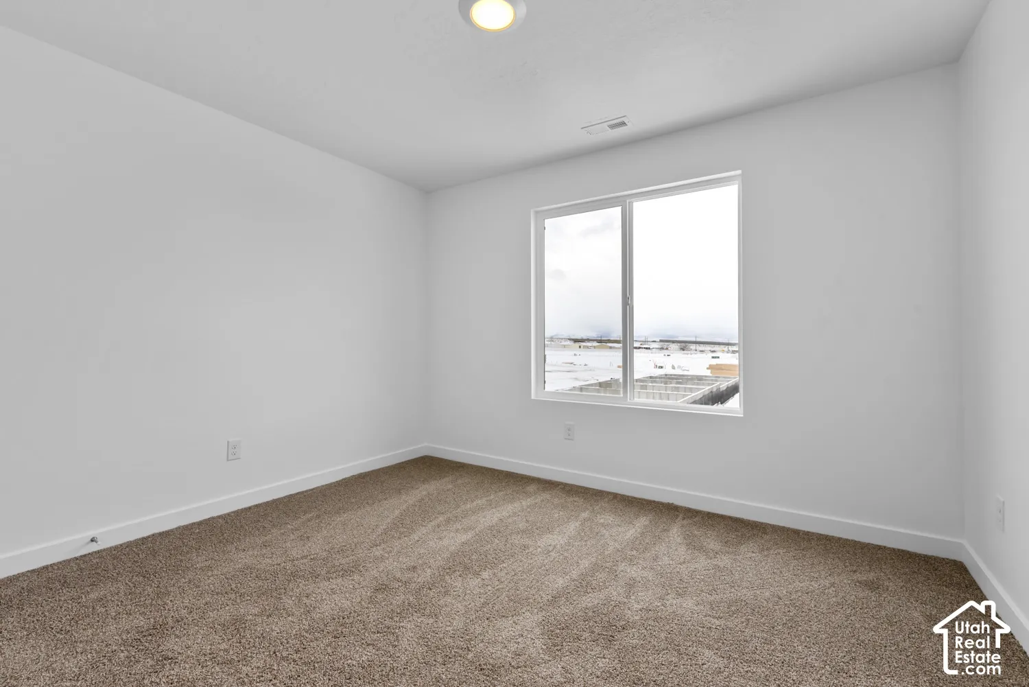 Neutral paint palette with a single window, recessed lighting, and carpeted flooring