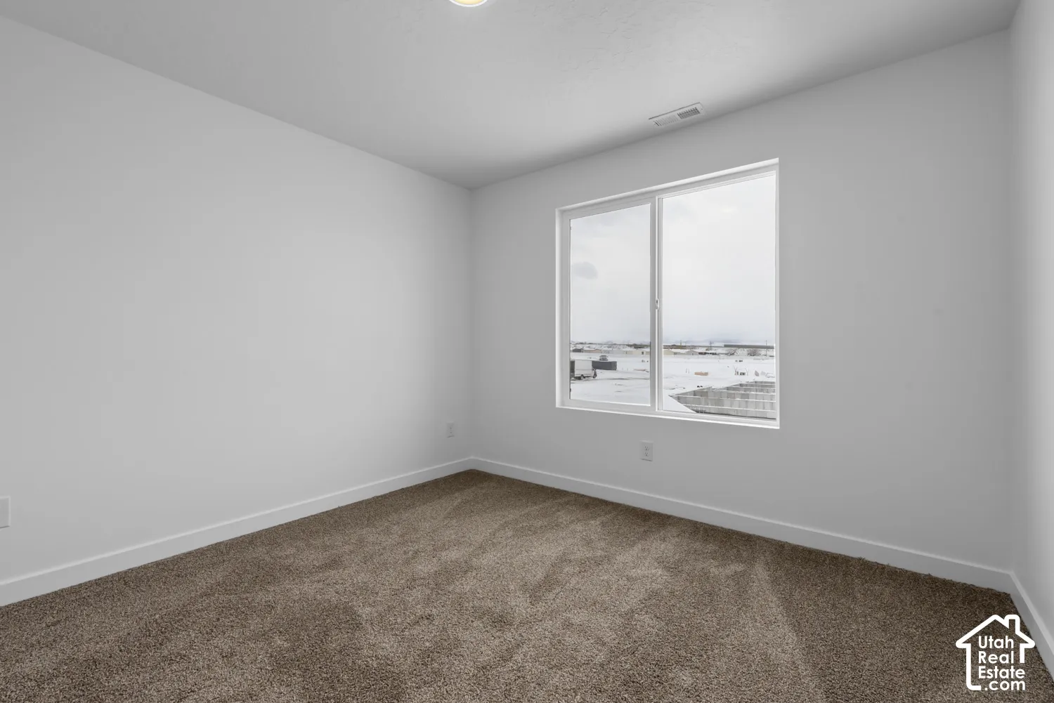 Neutral wall tones, recessed lighting, and carpeted flooring