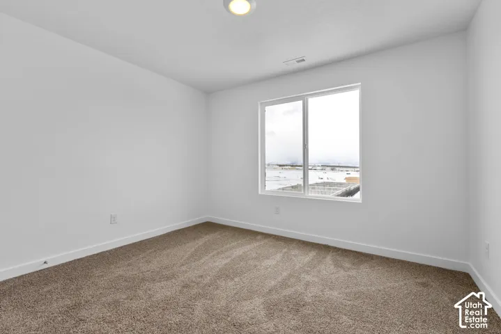 Neutral paint palette with a single window, recessed lighting, and carpeted flooring