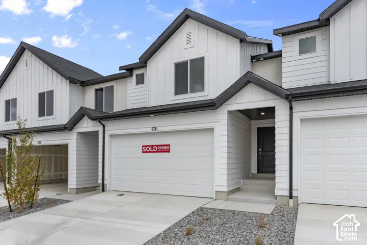 Contemporary townhouse exterior with white vertical siding and dark trim