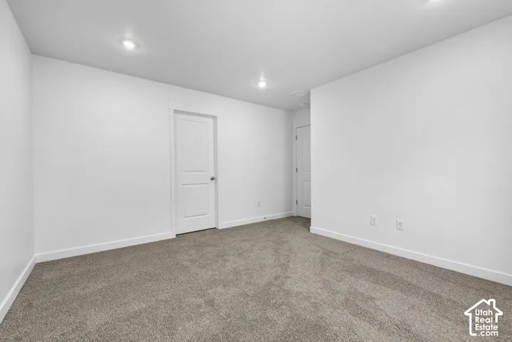 Neutral-toned carpeting with recessed lighting and a two-panel interior door
