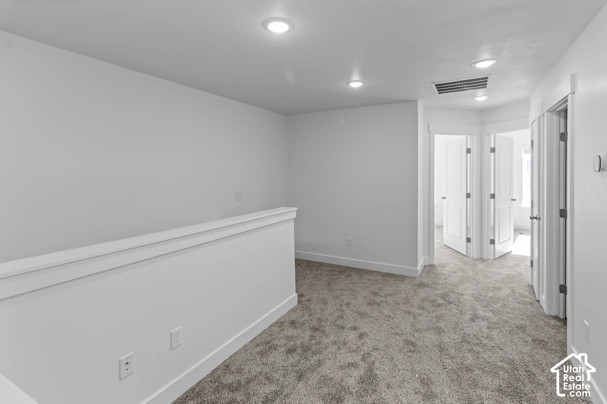 Carpeted flooring, recessed lighting, white walls, white trim, and interior doors with brushed nickel hardware