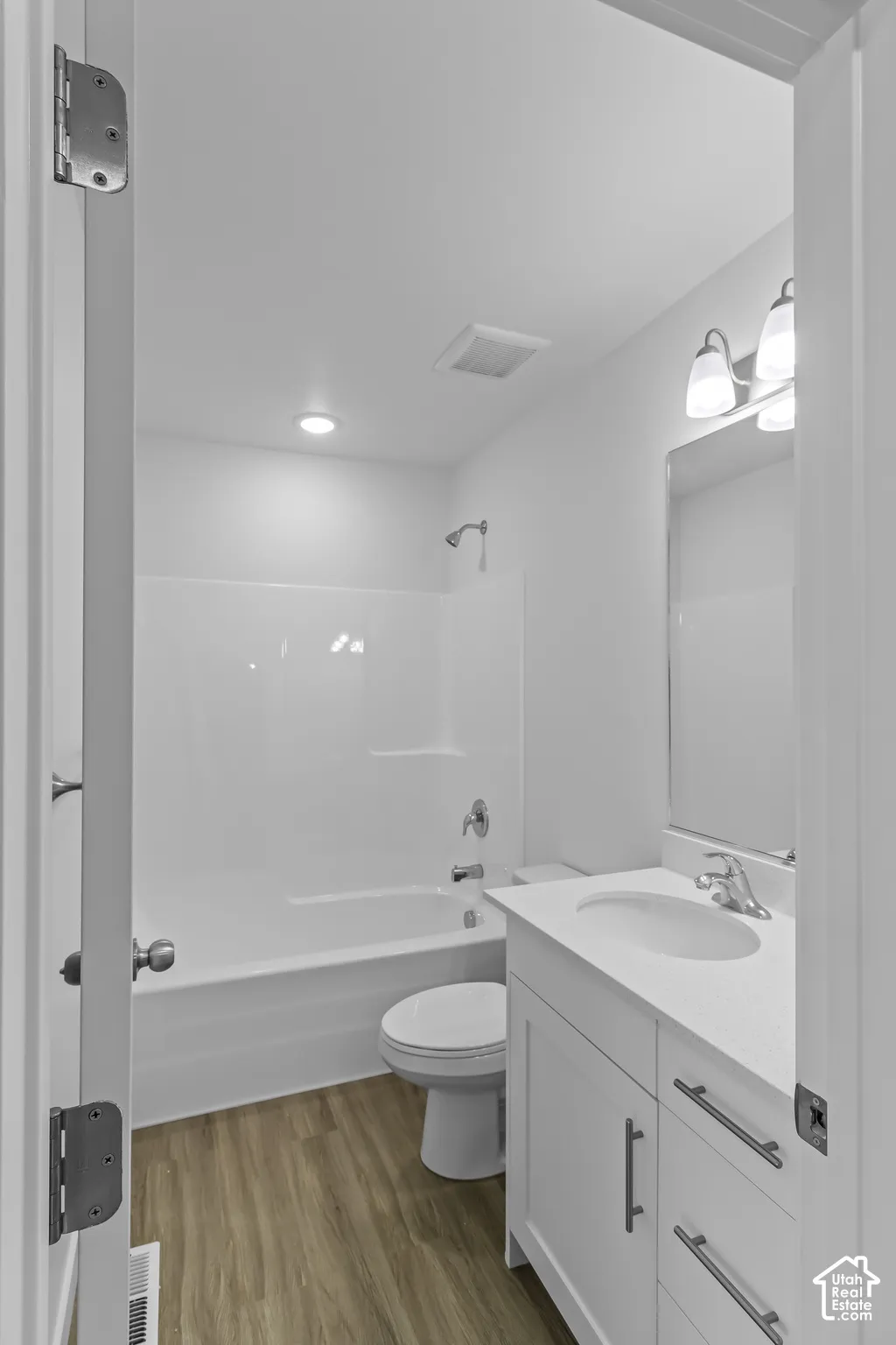 White single vanity with stone countertop, undermount sink, and chrome fixtures