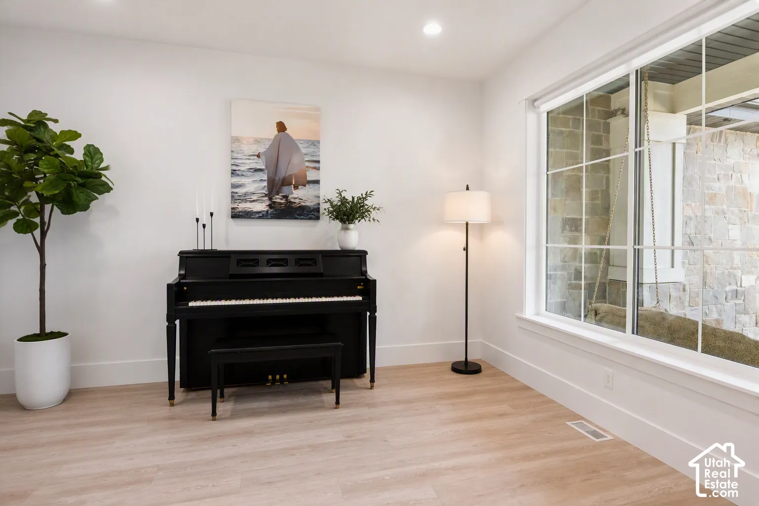 Light-toned wood-finish flooring, white walls, and a large multi-pane window with white trim