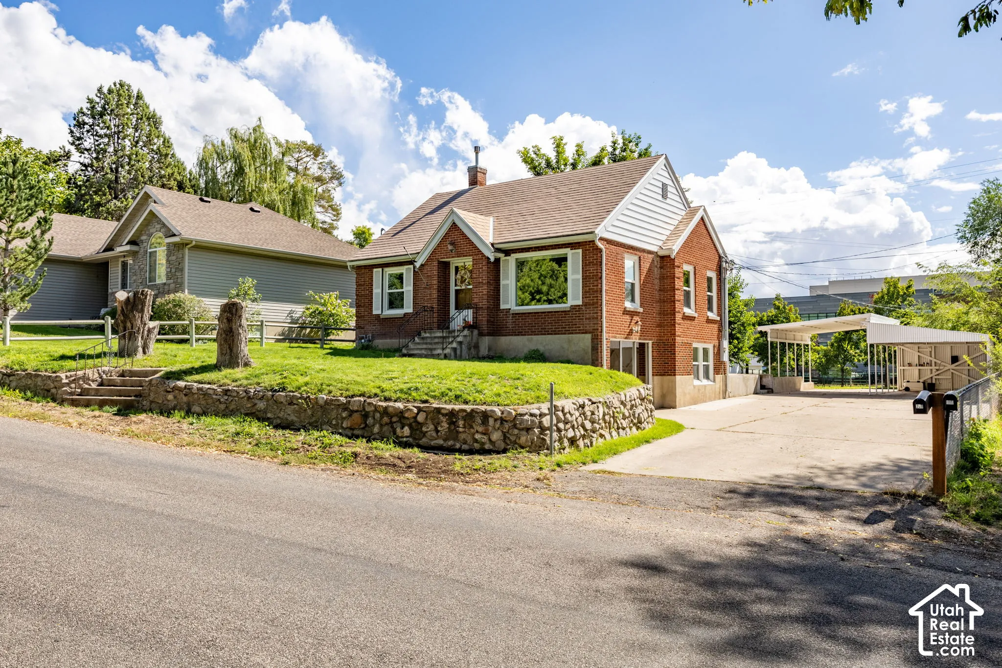 Brick facade with white window shutters and a gabled roof