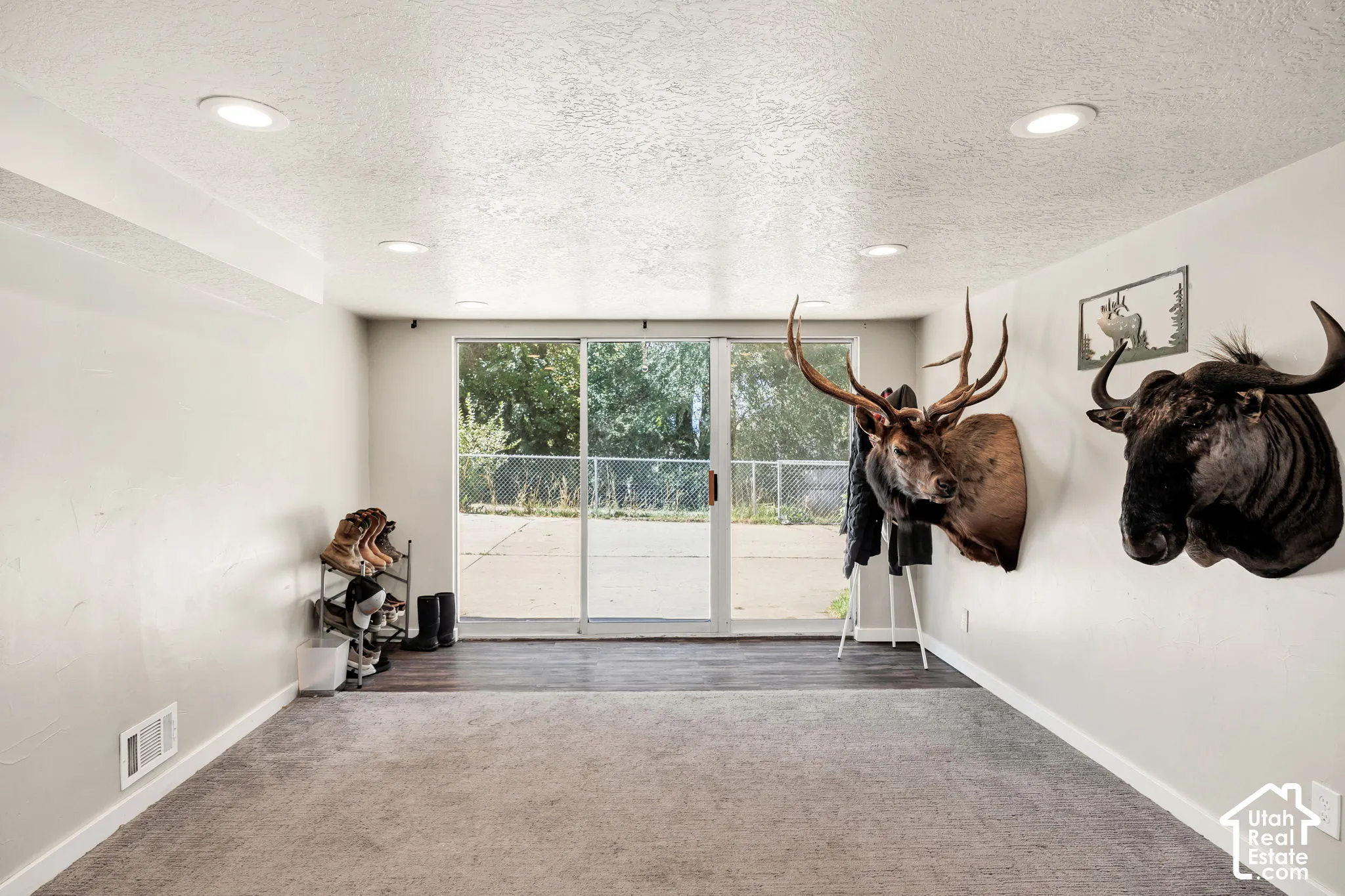 Recessed ceiling lighting, carpeted flooring, wood-finish flooring, sliding glass door, and white painted walls