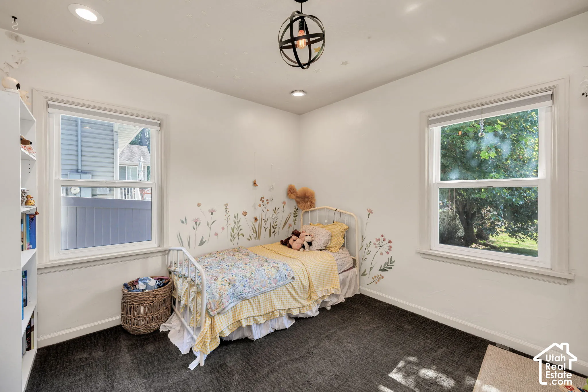 Recessed lighting, central chandelier, two single-hung windows, and dark-toned carpeting