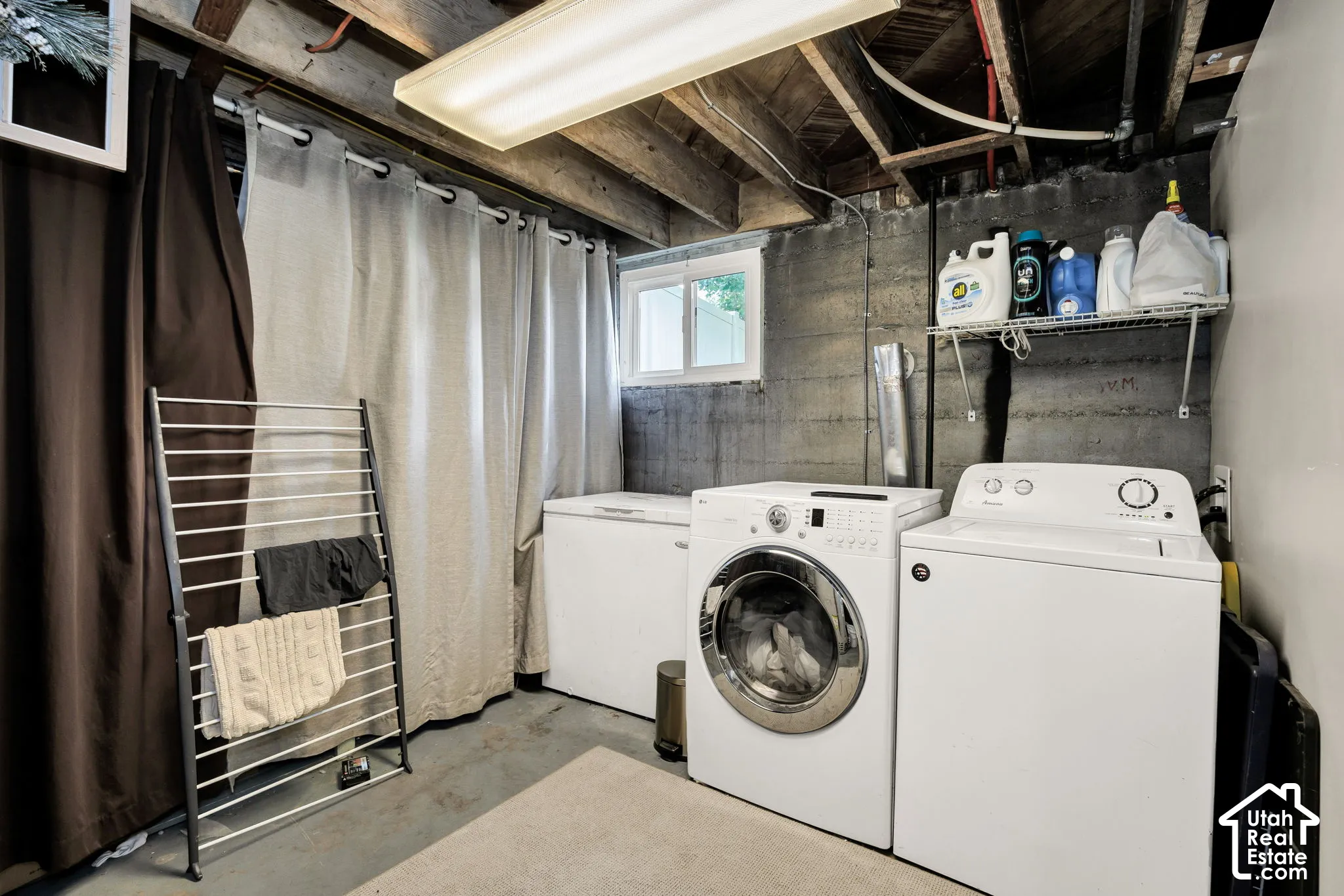 Laundry area featuring a front-load washer, top-load dryer, and a built-in wire shelf