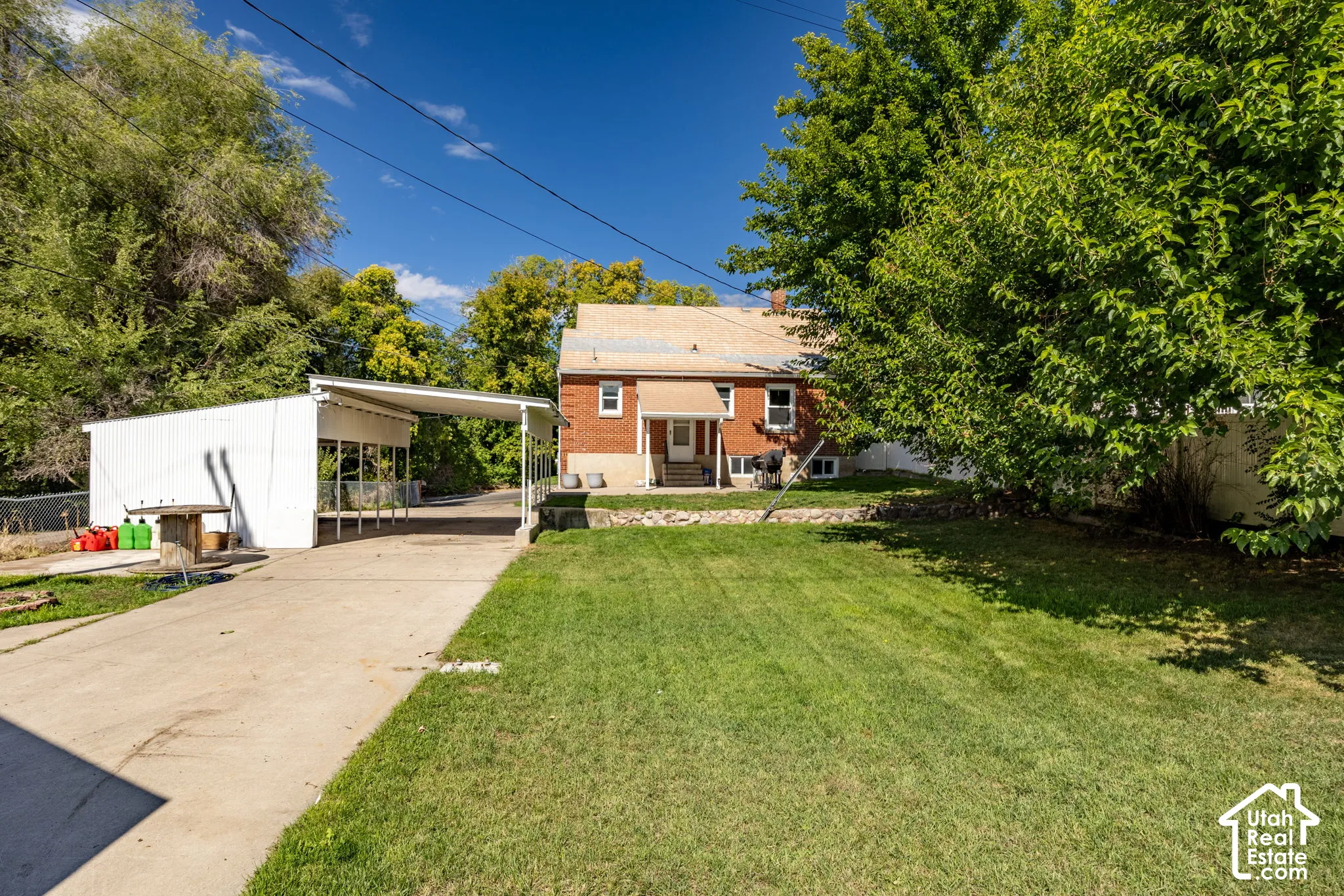 Brick exterior residence with a single-story porch and carport
