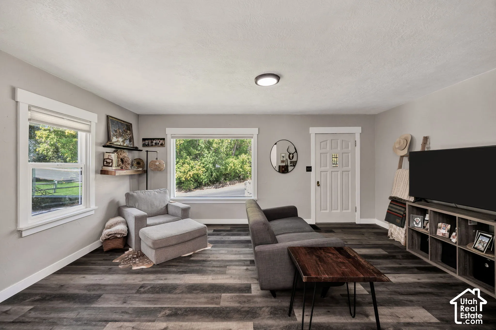 Light gray wall paint, contrasting white trim, wood-finish LVP flooring, recessed ceiling lighting, and a white front entry door