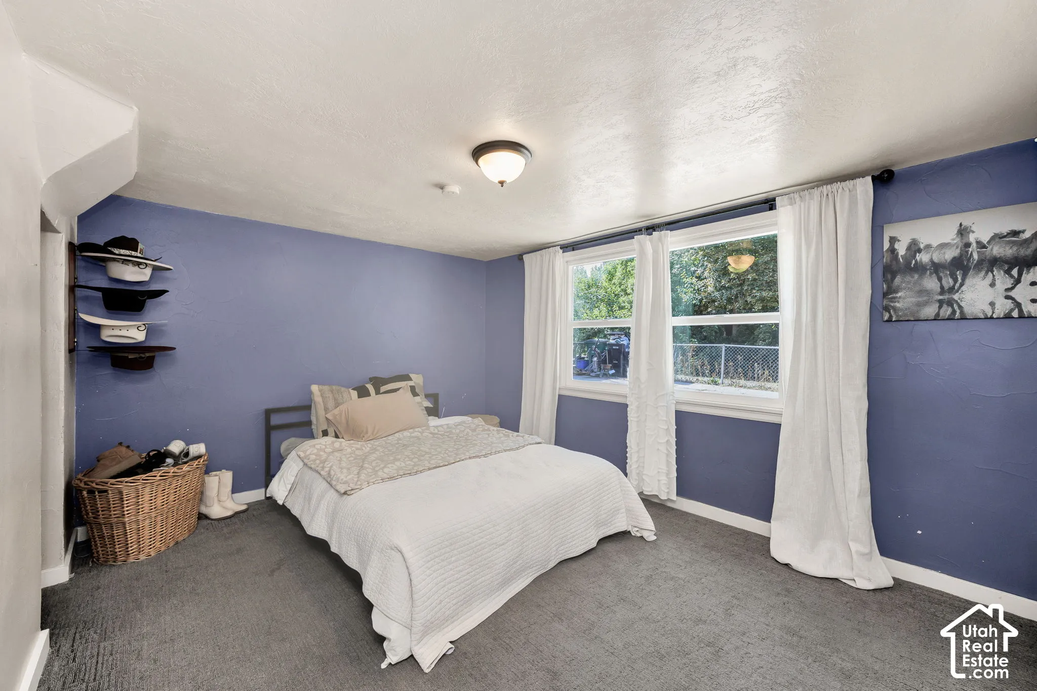 Downstairs bedroom, carpeted flooring, two windows, and a flush mount light fixture