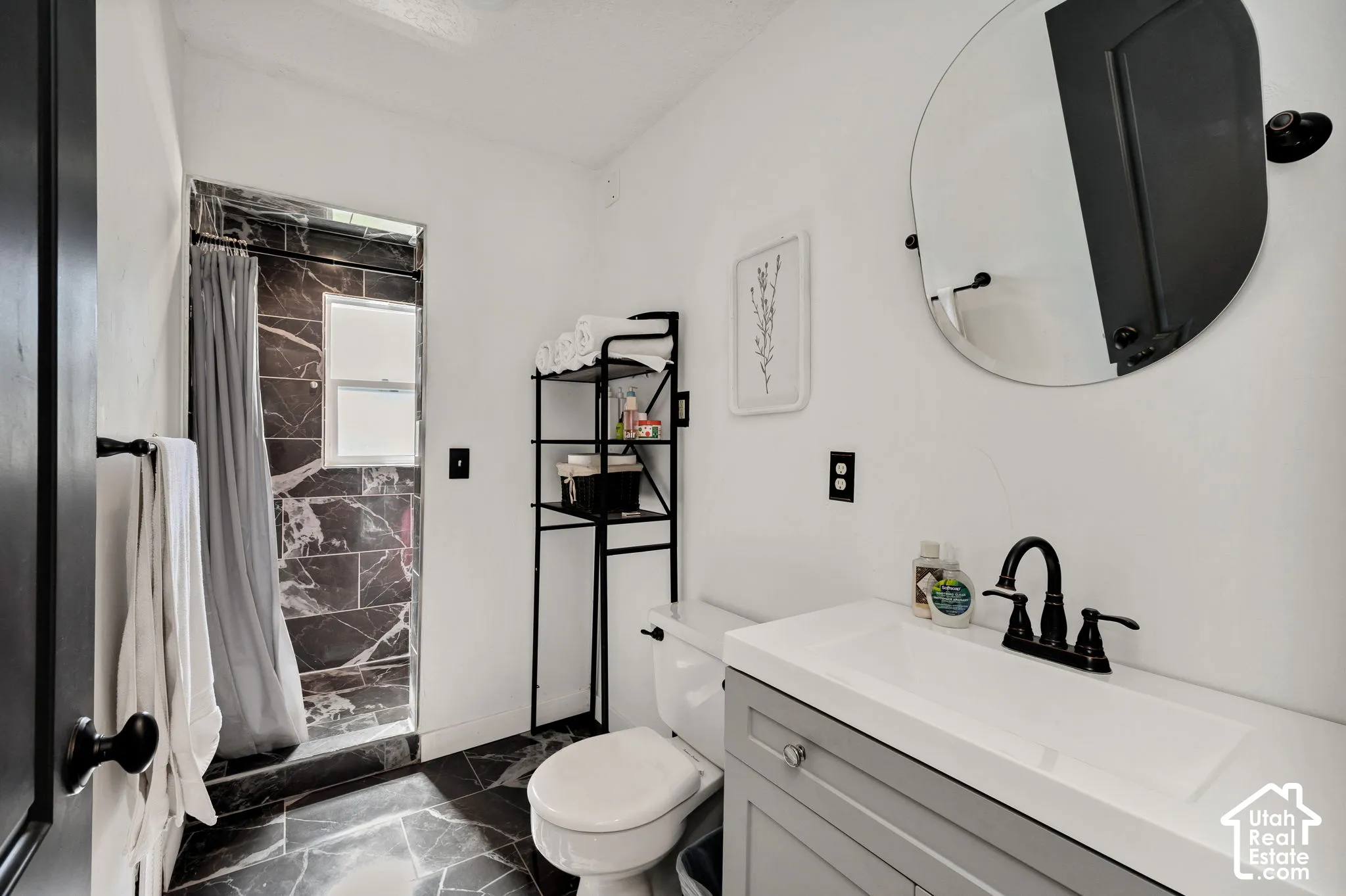 Main bath, Floor-to-ceiling black and white marbled tile shower, with an integrated window, white walls, white sink with grey shaker style cabinet
