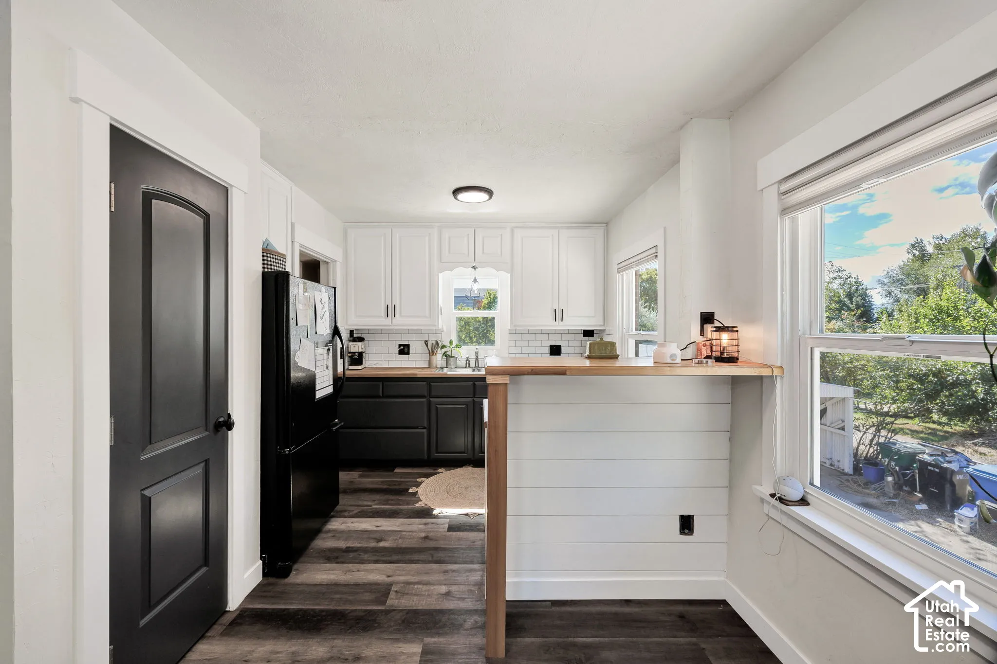 Modern kitchen featuring wood-finish flooring and white upper cabinetry