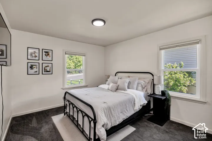 Main bedroom, White walls, recessed lighting, and dark carpet flooring.