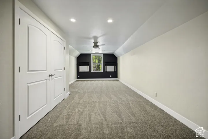Recessed lighting, patterned carpeting, a ceiling fan, and white paneled doors