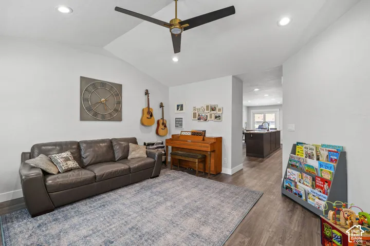 Vaulted ceiling with recessed lighting and a ceiling fan, wood-finish flooring, and light-toned walls