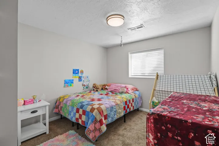 Neutral wall paint with textured ceiling, a flush-mount ceiling light fixture, and a window with blinds