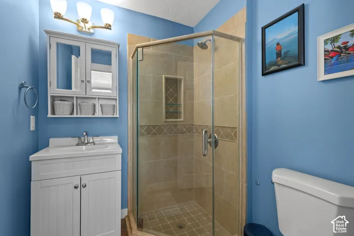 White vanity with a rectangular sink, wall-mounted medicine cabinet, and a three-light fixture