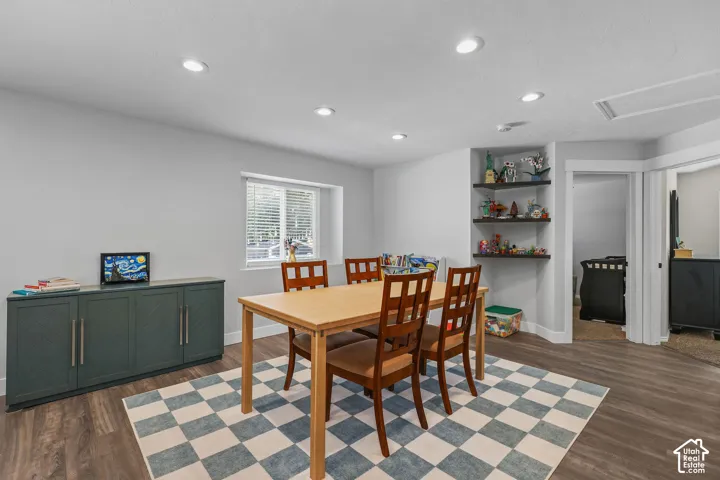 Recessed lighting illuminates the space, featuring wood-finish flooring and a window with blinds