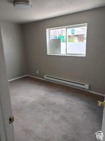 Recessed window with baseboard heating and overhead flush-mount lighting