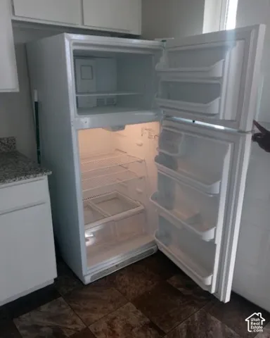 White two-door refrigerator with upper freezer compartment, integrated shelving, and crisper drawers