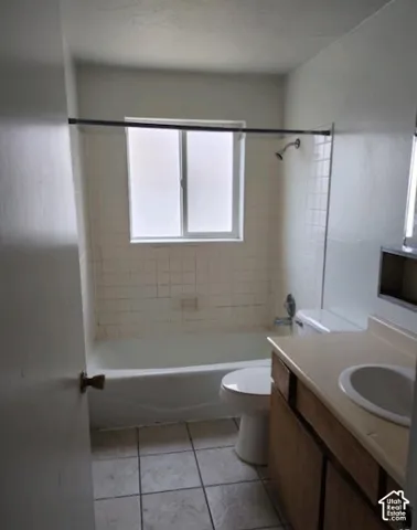Bathroom featuring a single vanity, integrated sink, and white ceramic tile flooring