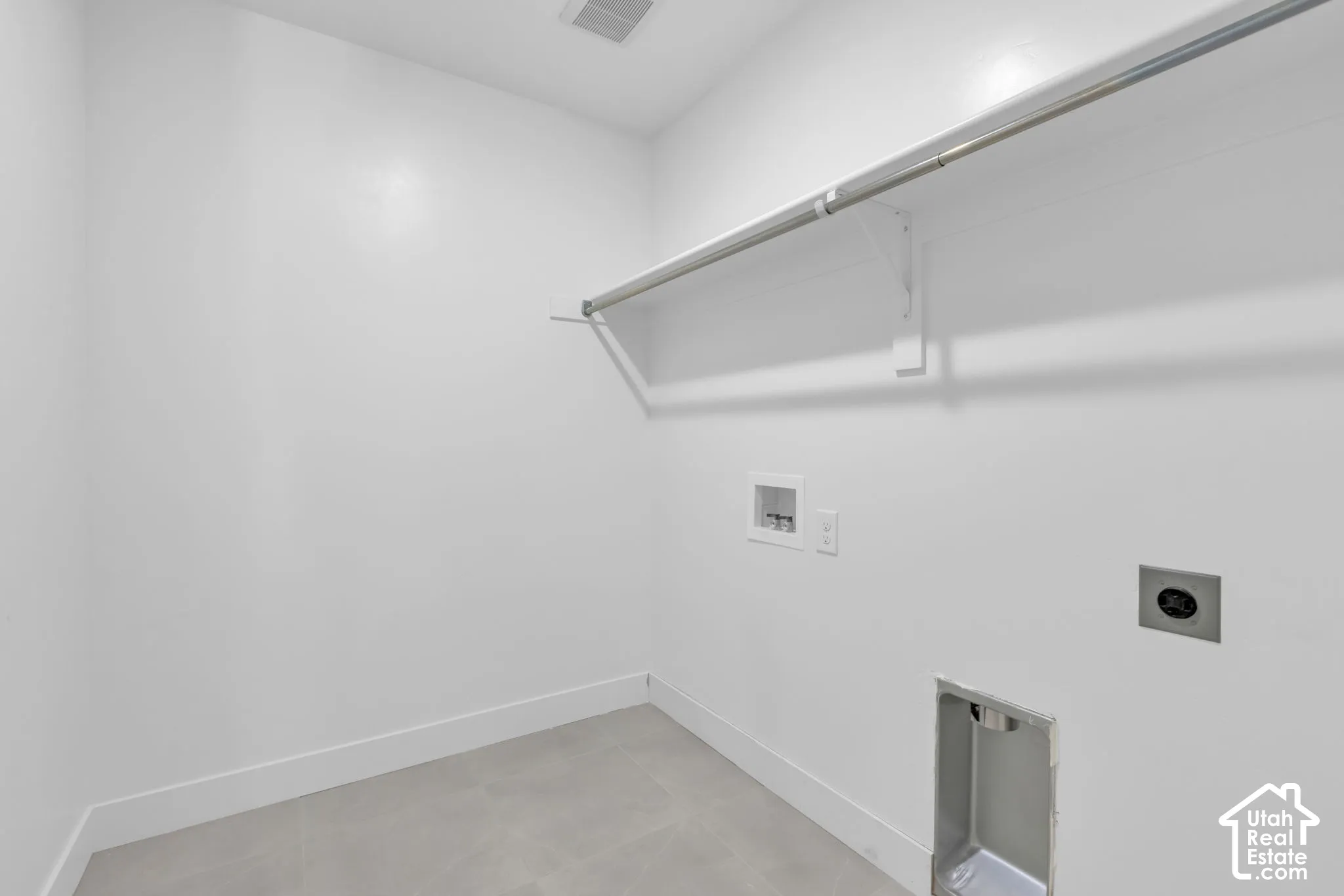 Dedicated large laundry room featuring tile flooring, and utility hookups.