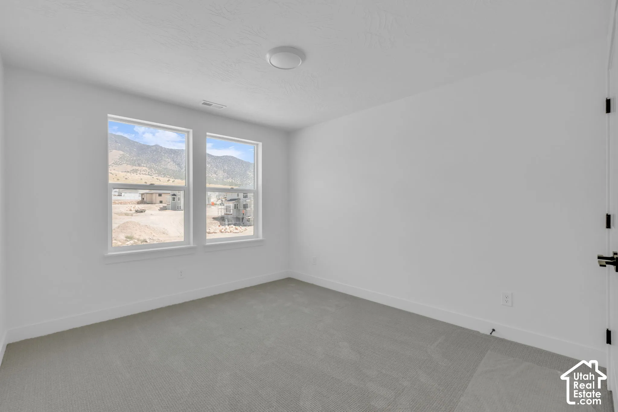 Spacious bedroom featuring dual single-hung windows with mountain views.