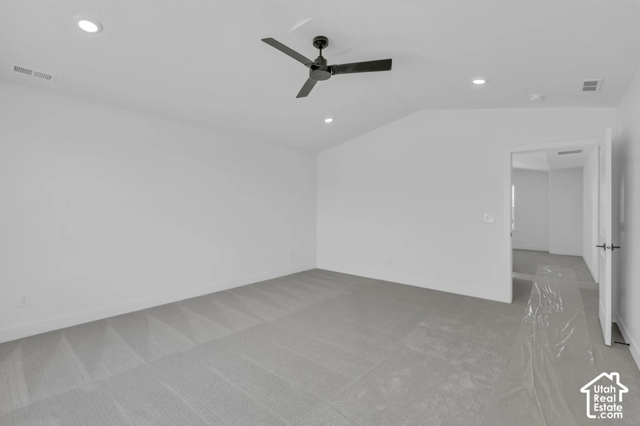 Spacious primary bedroom with vaulted ceiling.