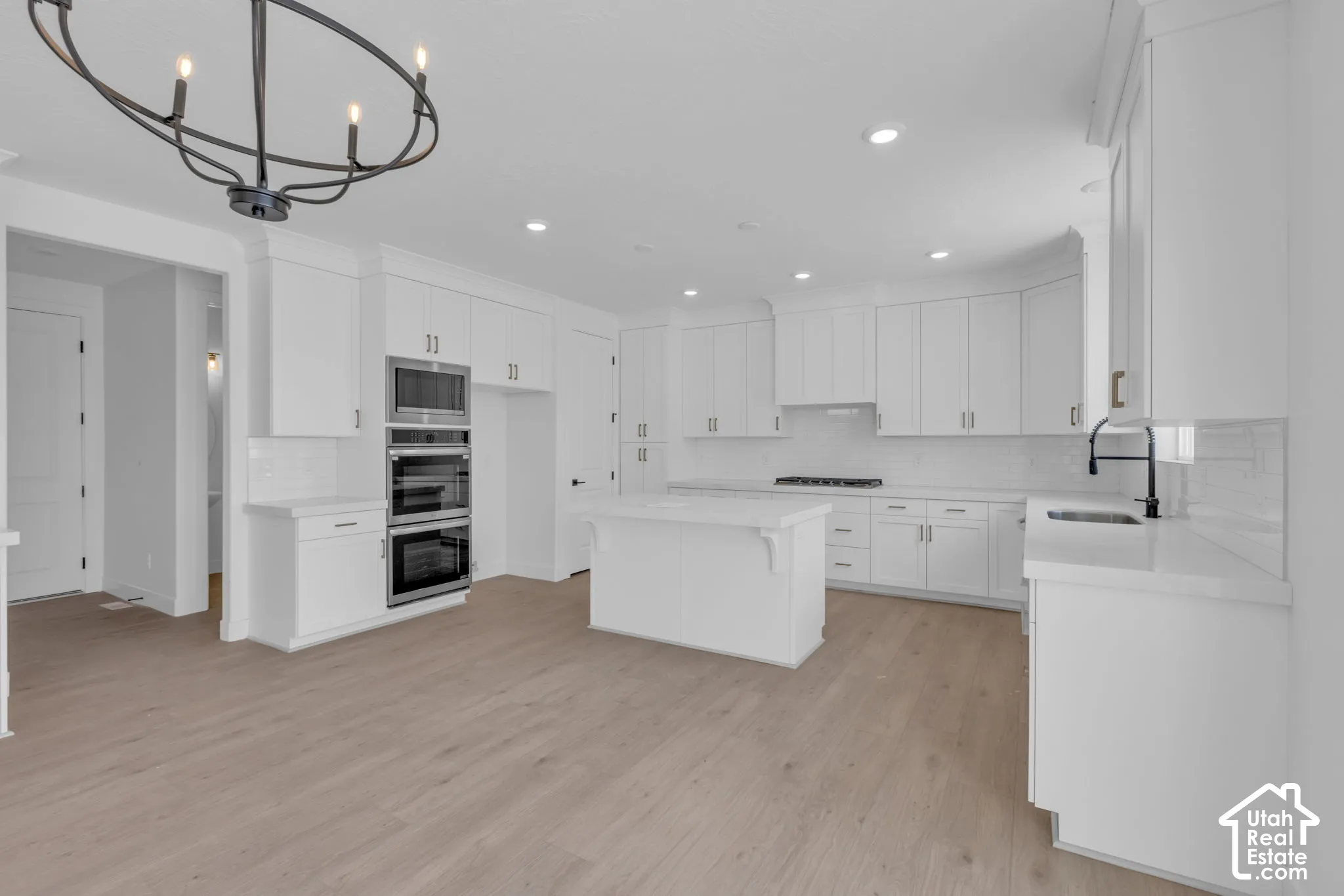 Spacious kitchen featuring full-height cabinetry, a central island, and stainless steel gourmet appliances to include a gas cooktop and double ovens.