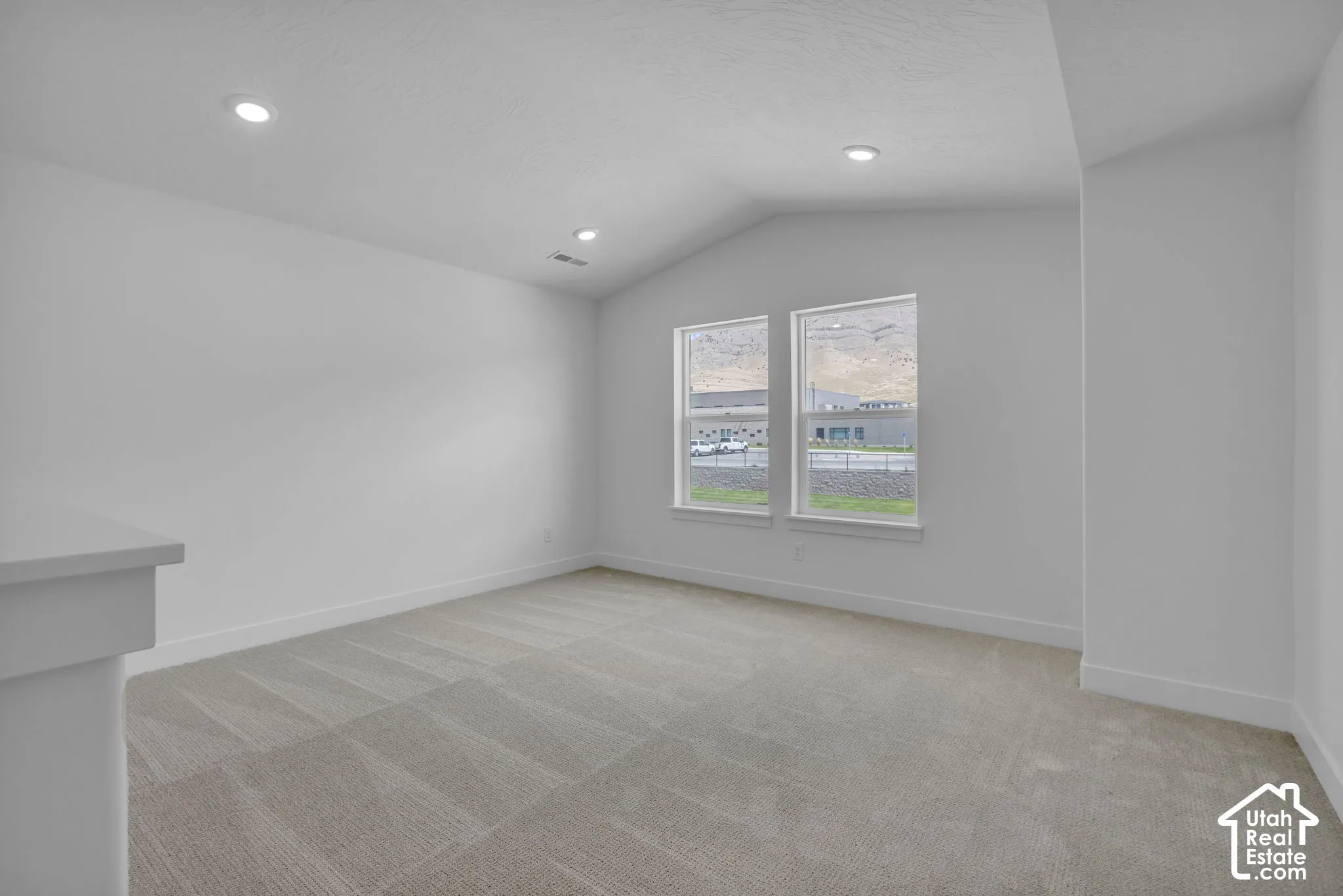 Media room or loft with vaulted ceiling and windows with mountain views.