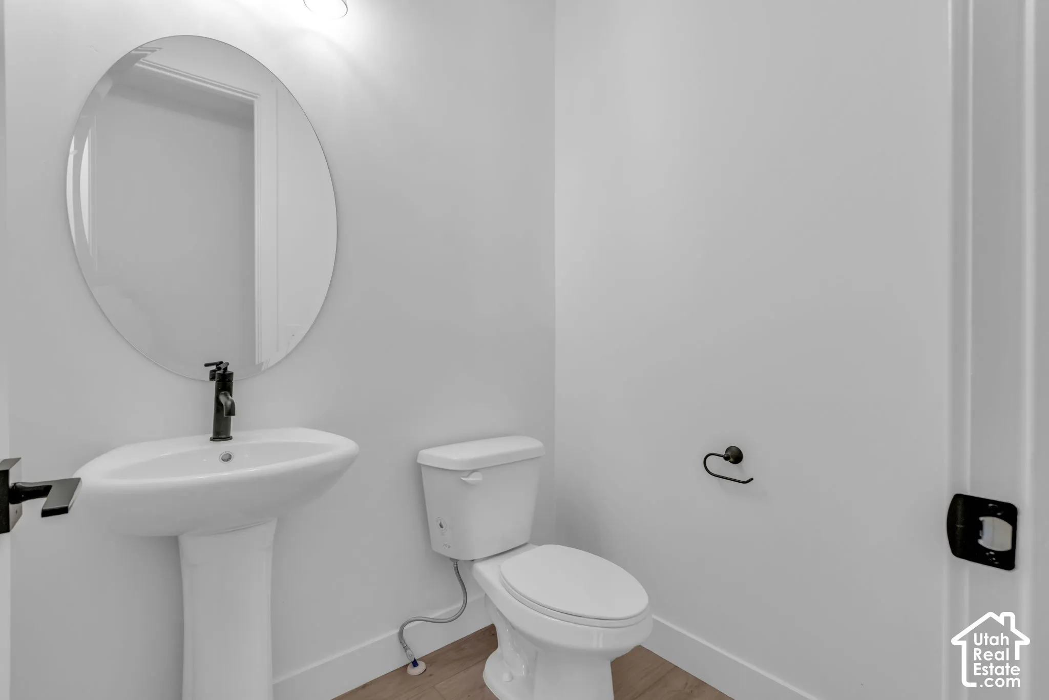 Powder bath with pedestal sink and matte black faucet.