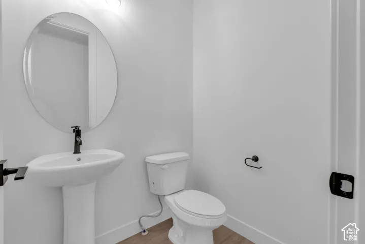Powder bath with pedestal sink and matte black faucet.