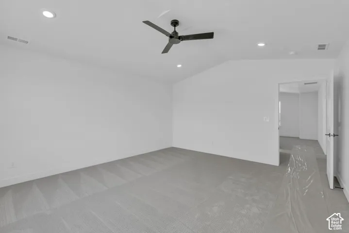 Spacious primary bedroom with vaulted ceiling.