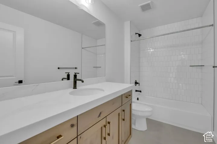 Two of two secondary bathrooms with white subway tile shower surround, natural stained cabinets and oversized quartz countertops.