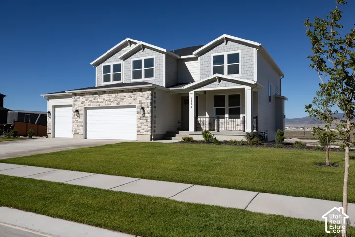 Our Magnolia, with an extended large front porch, stone and RV height third car garage.