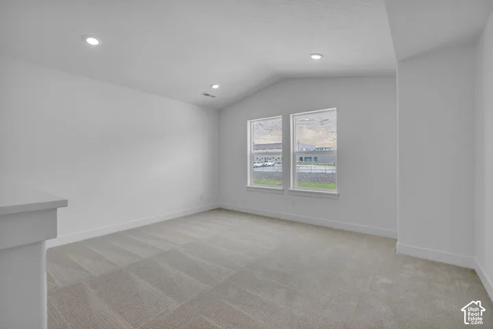 Media room or loft with vaulted ceiling and windows with mountain views.