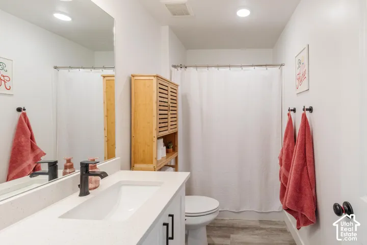 White vanity with an integrated rectangular sink, dark bronze faucet, and black hardware