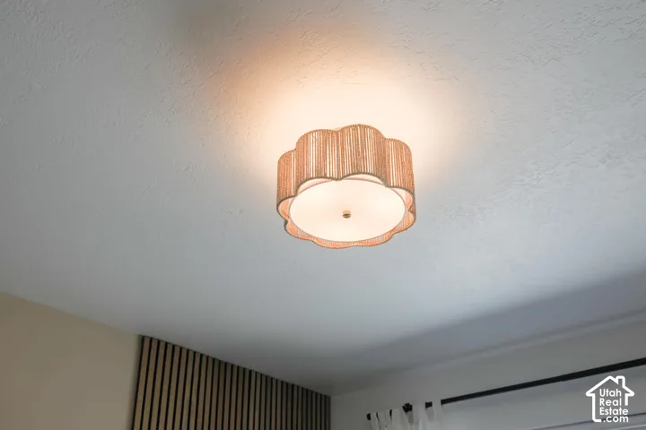 Ceiling-mounted light fixture with a scalloped fabric shade and white diffuser