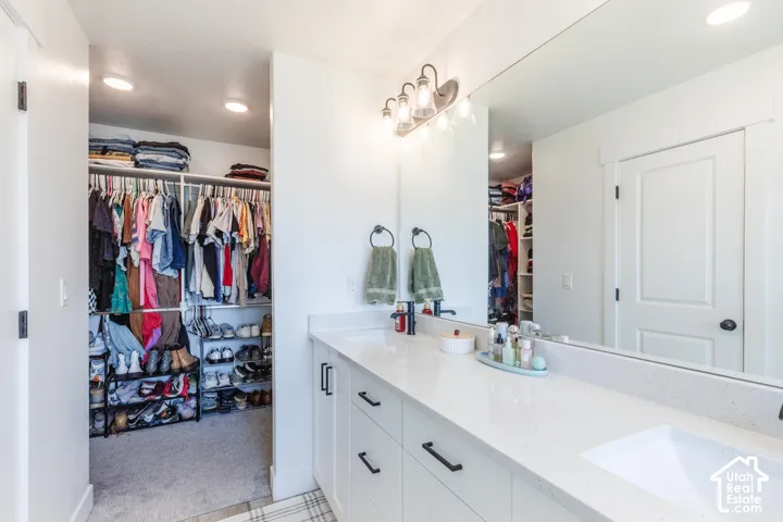 Dual sink vanity with white cabinetry and dark hardware
