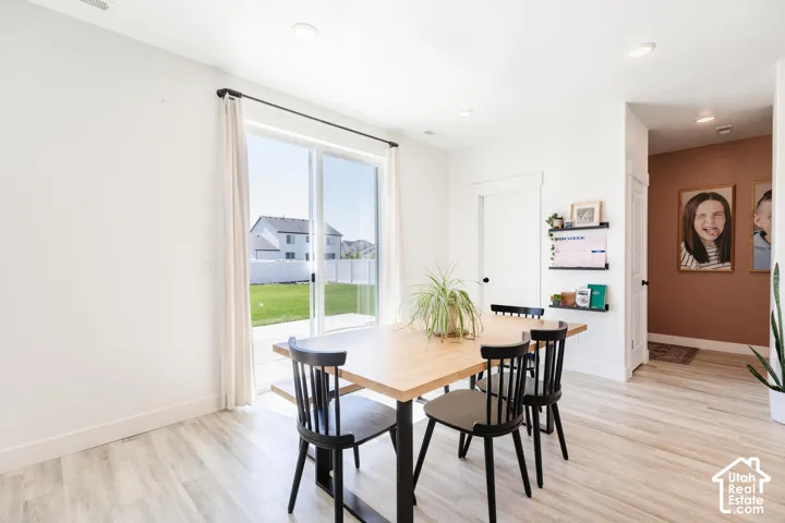 Sliding glass door, light wood-finish flooring, recessed lighting, white interior walls, white trim