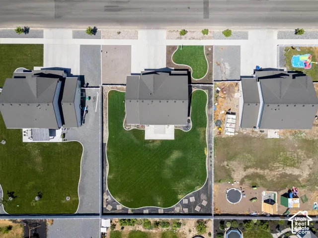 Expansive green lawn with a curvilinear border, surrounded by a paved perimeter