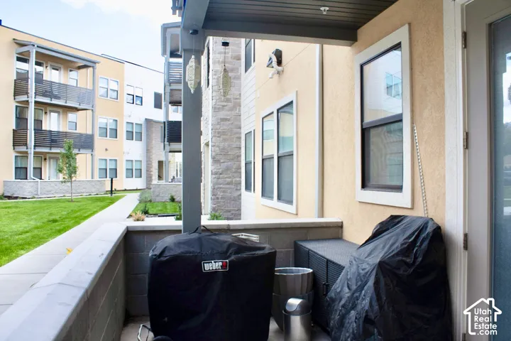 Patio with stucco exterior, a concrete half-wall, and a concrete paver walkway