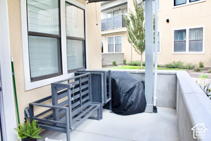 Private patio area featuring a concrete surface and a partial block wall