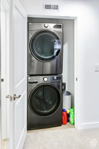 Stacked stainless steel washer and dryer units in a dedicated closet