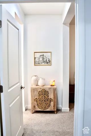 Neutral tone wall color, recessed lighting, and light-colored carpeting