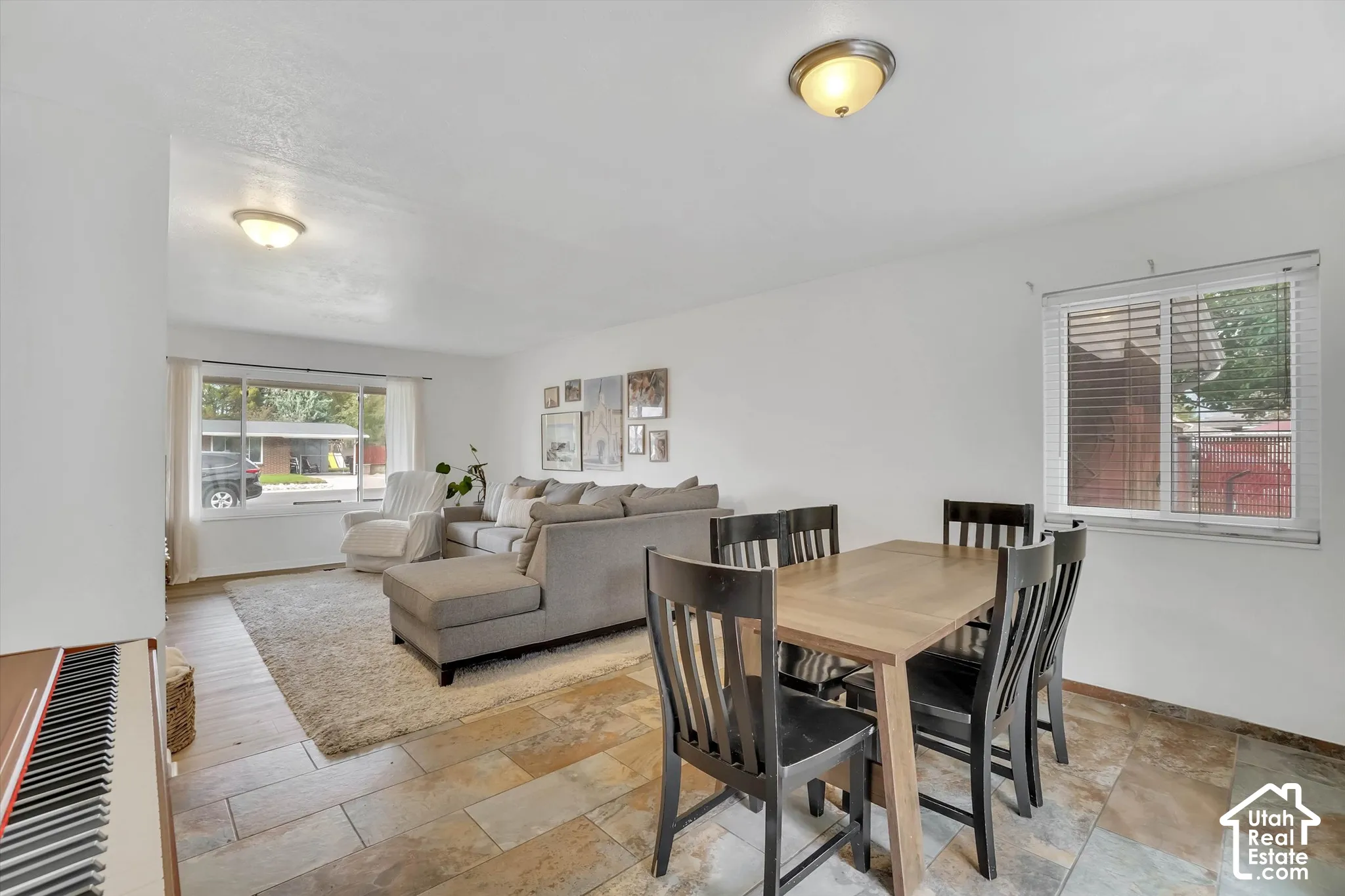 Expansive room with neutral white walls, a large front-facing window, and a smaller side window