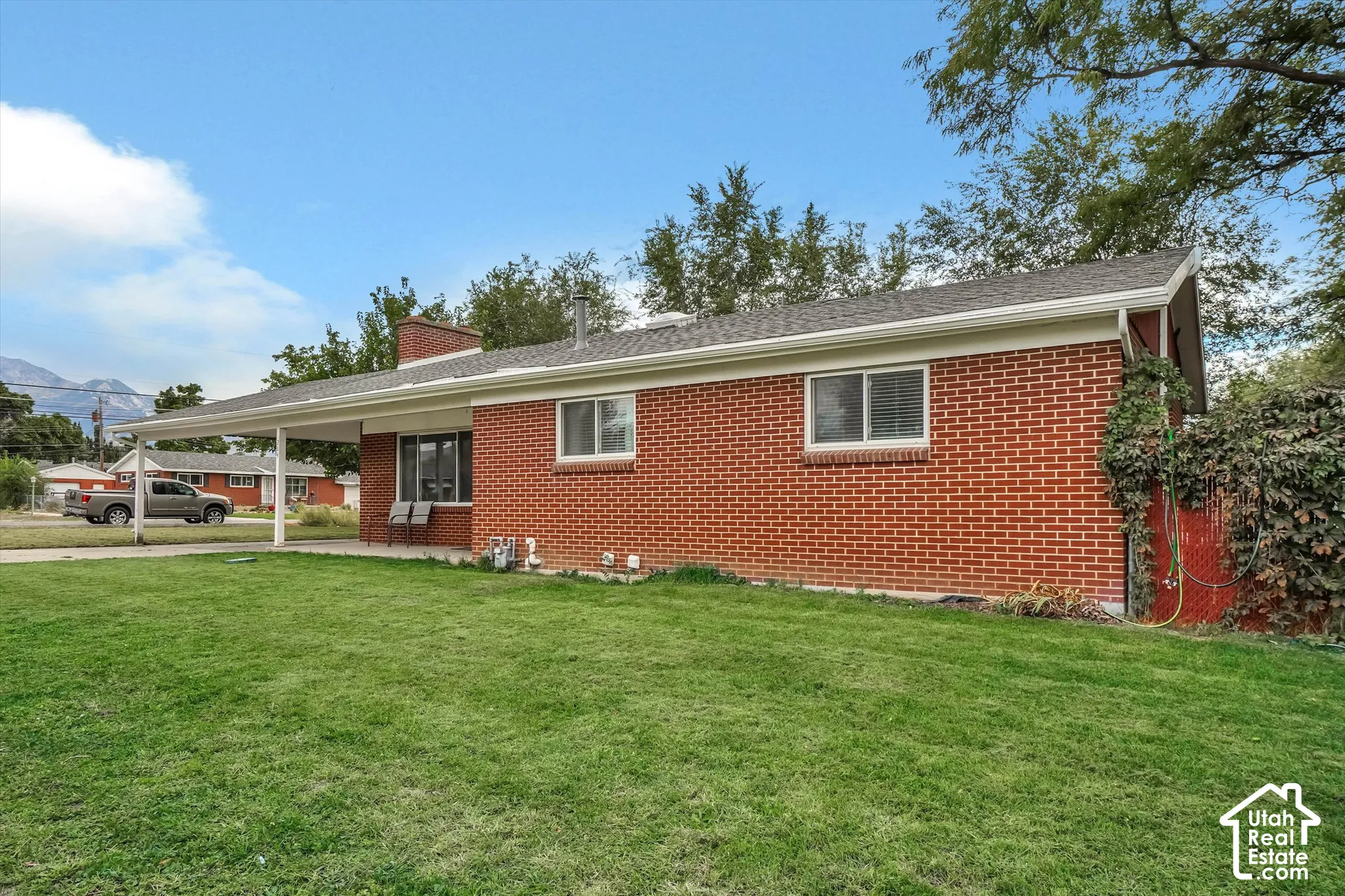 Brick exterior with a carport and a pitched roof