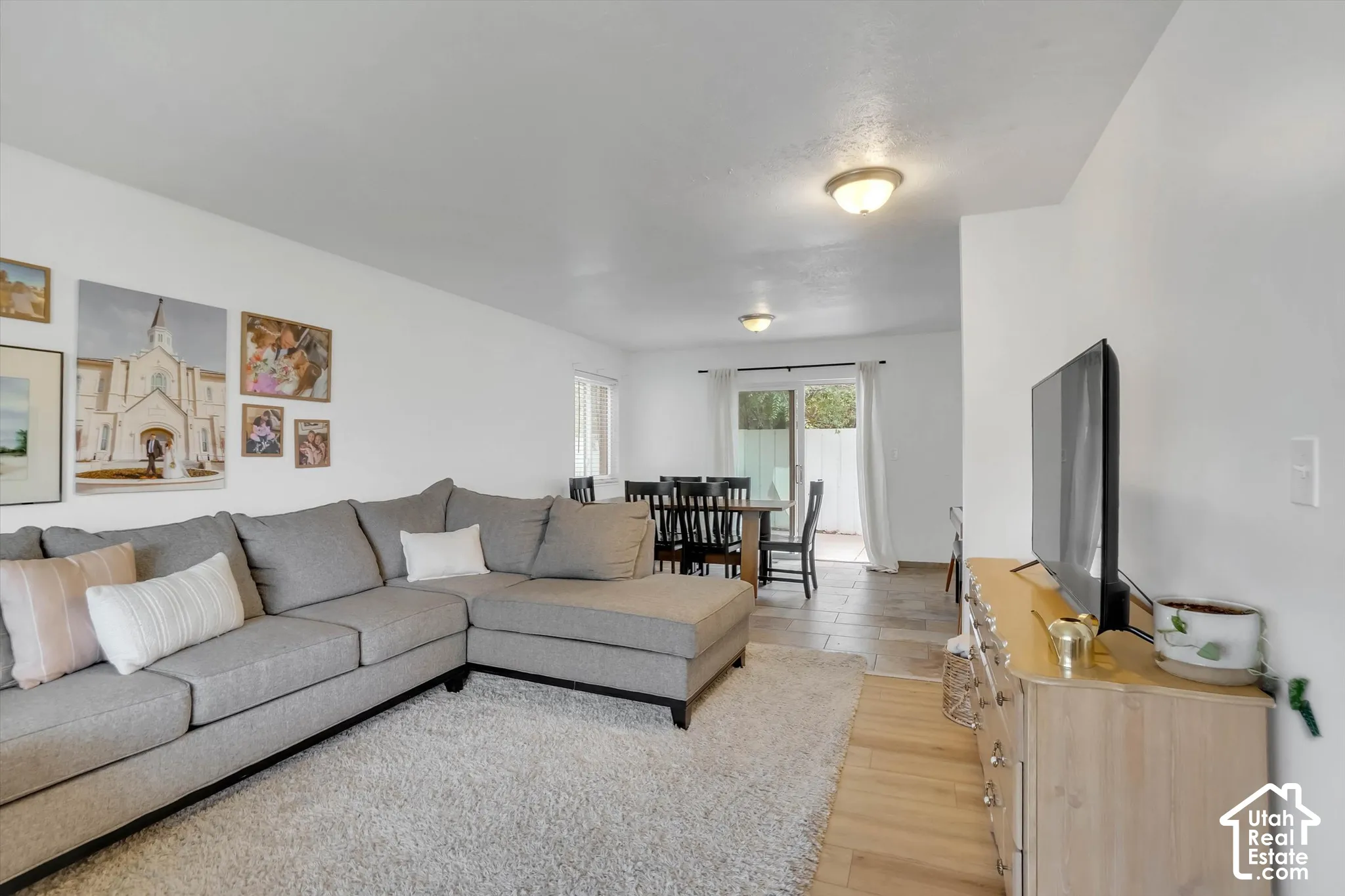 Open-concept living space featuring wood-finish flooring, recessed lighting, and a dining area with direct outdoor access
